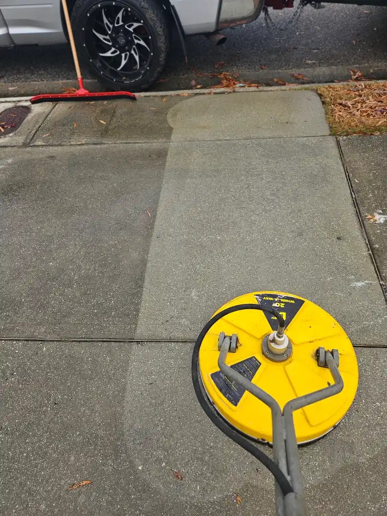 Worker pressure washing commercial equipment